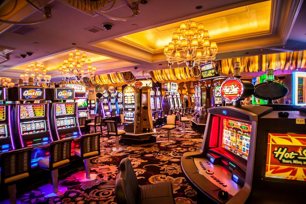Deretan mesin slot di lantai kasino dengan lampu warna-warni