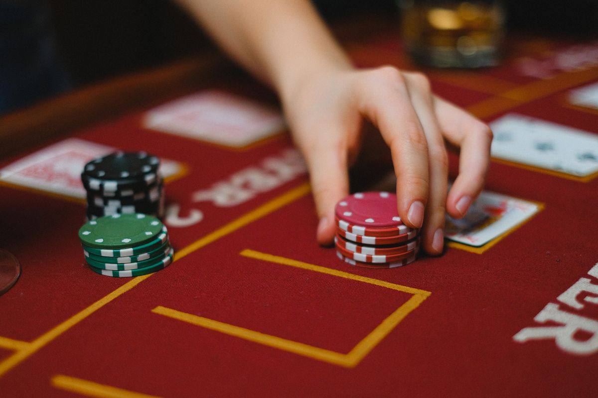 Tangan memasang chip di meja permainan